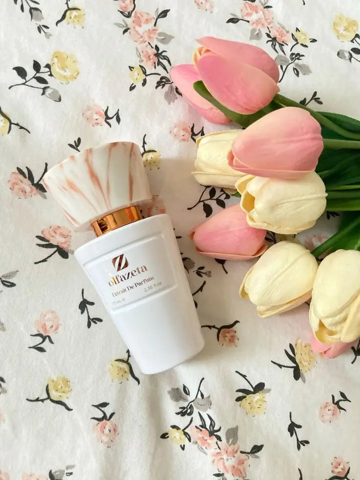 Parfum Chogan sur une table à côté de fleurs colorées.