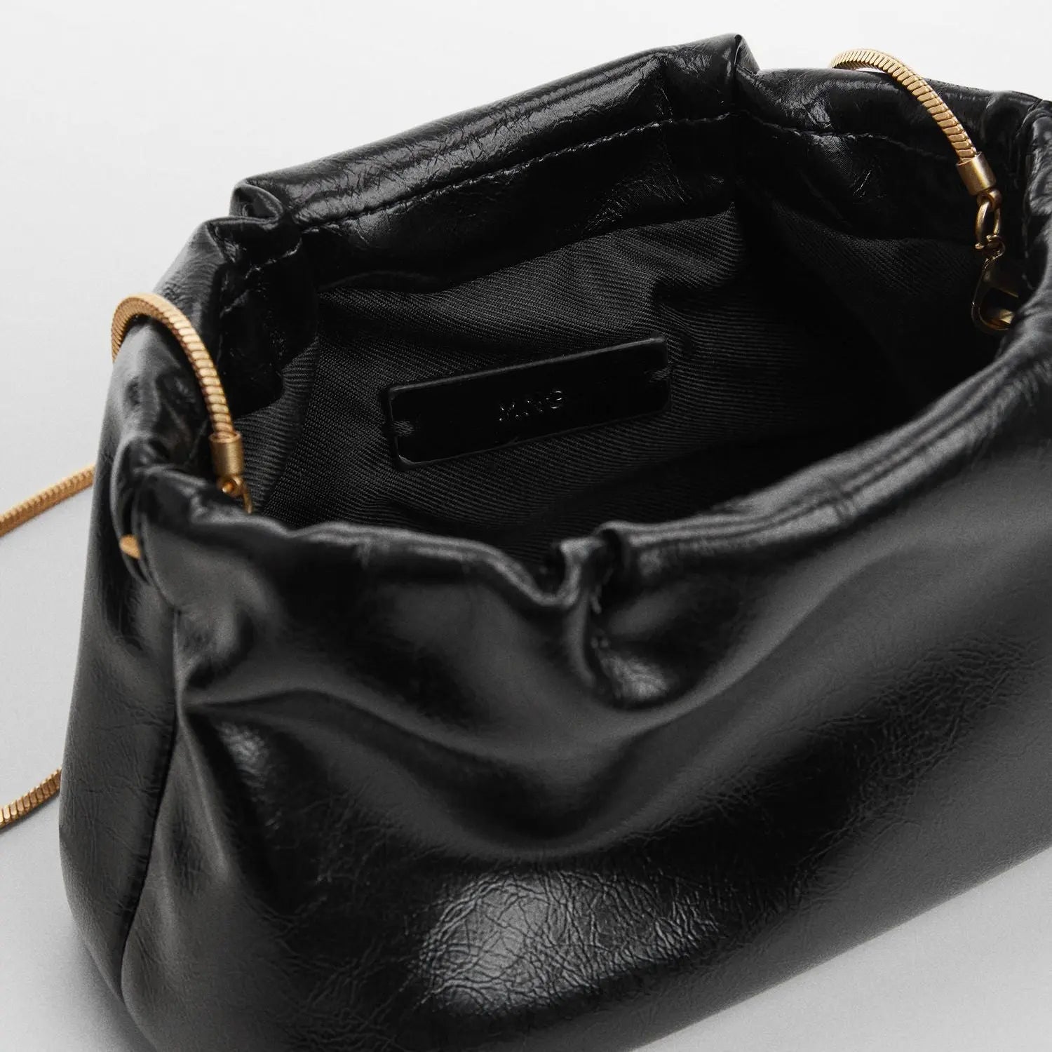 Sac à main en noir élégant avec une bandoulière en chaîne dorée et un design minimaliste vue interieur